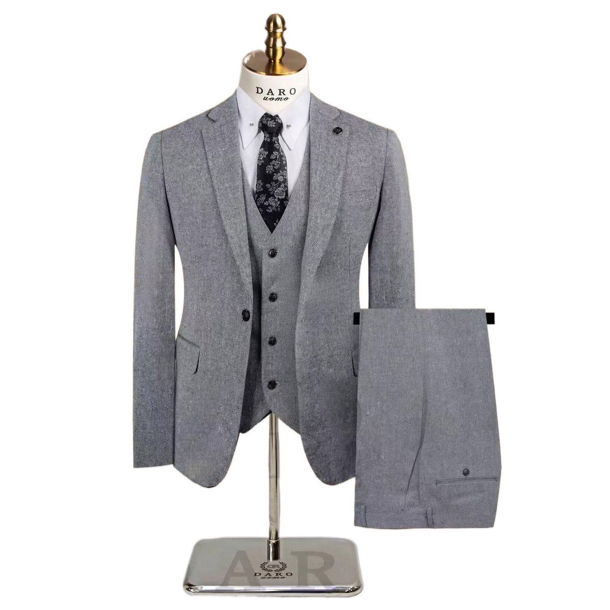 A men's grey textured three-piece suit with a single-breasted jacket, vest, and trousers, featuring black elbow patches on