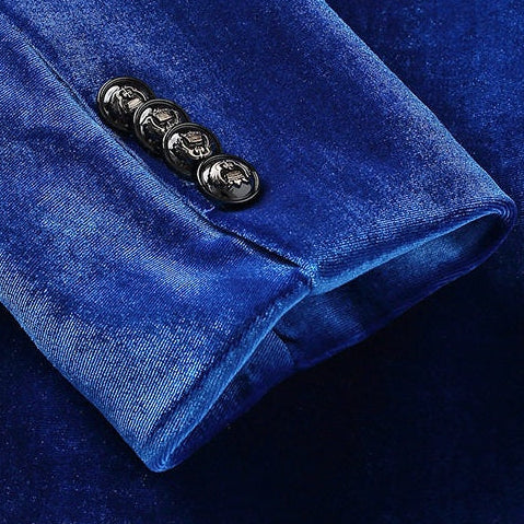 A collection of men's velvet suits in blue, red, gold, purple, and green, each featuring a one-button blazer with a feather