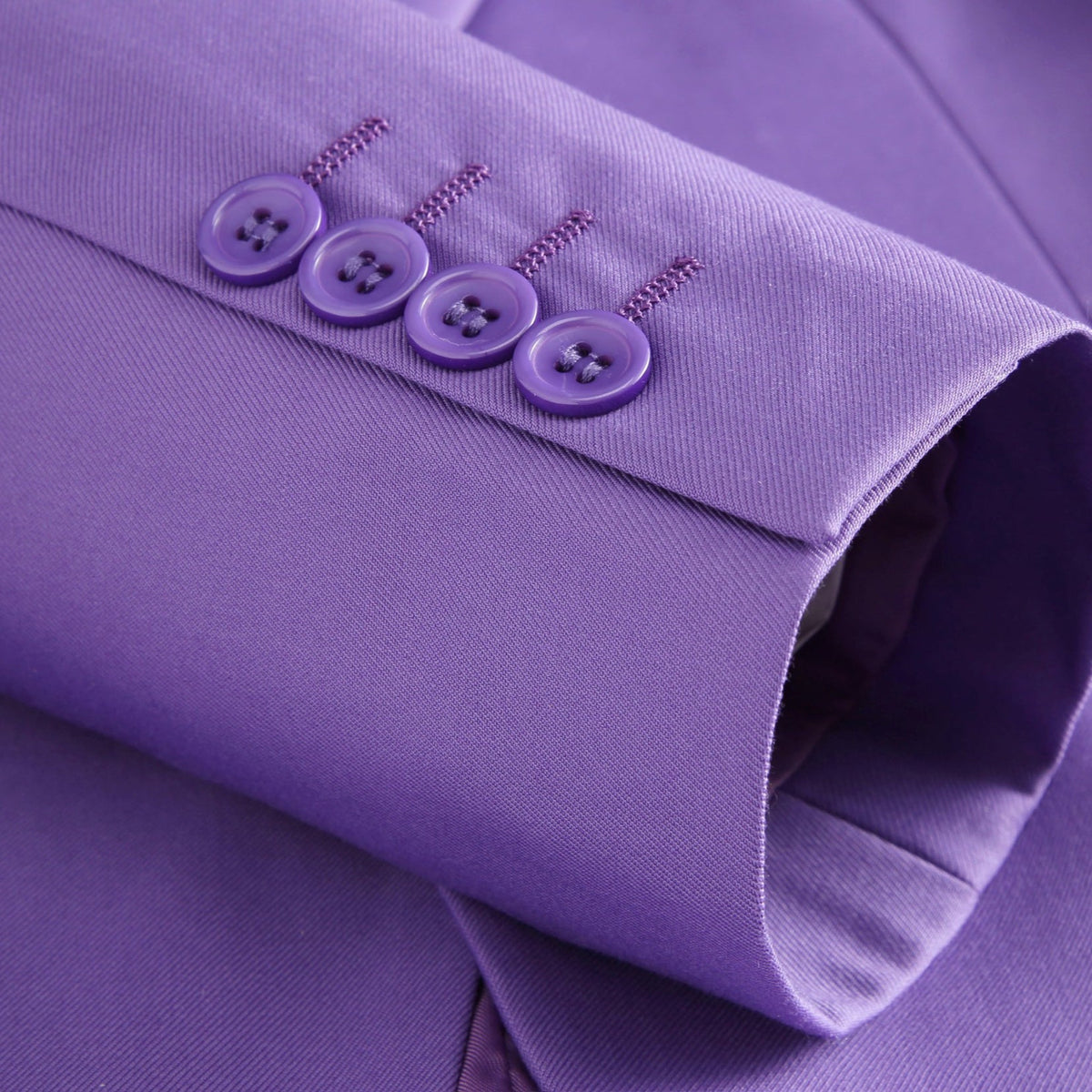 Men's purple three-piece suit, including a blazer, vest, and trousers, displayed on a mannequin with a white shirt and