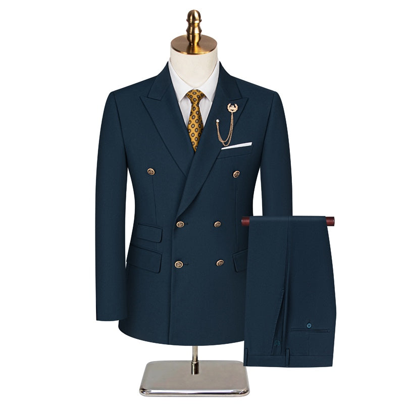 Front view of a men's dark blue double-breasted suit with a yellow patterned tie and a gold chain lapel pin on a mannequin.