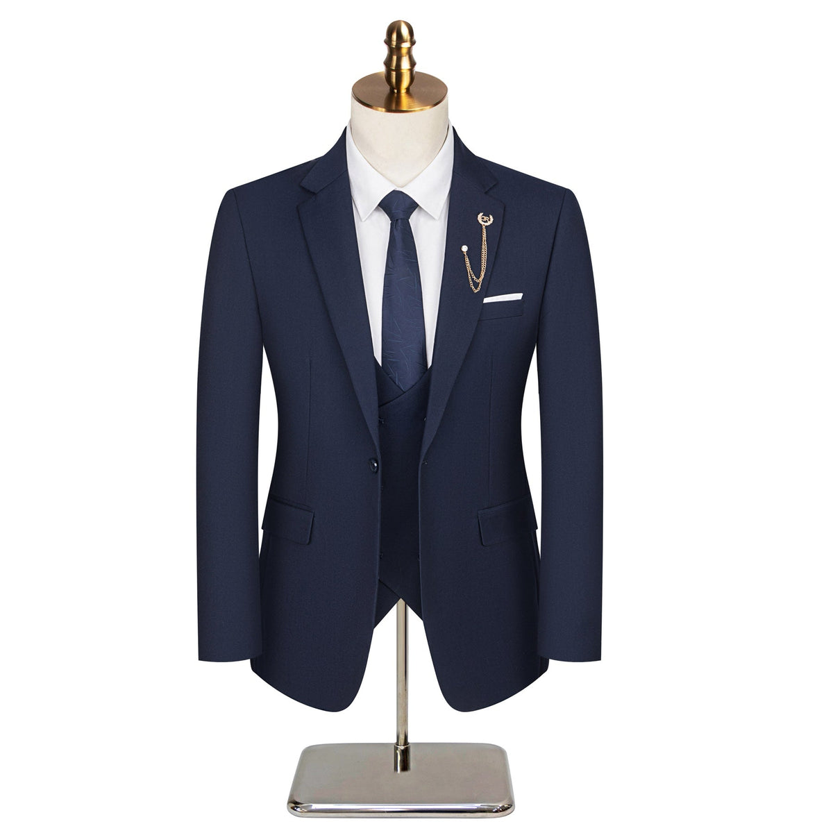 Full view of a men's navy blue three-piece suit with a white shirt, patterned tie, and gold chain lapel pin on a mannequin.