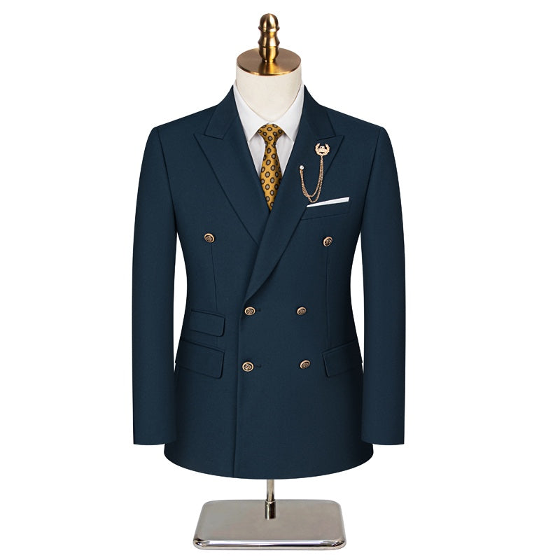 Front view of a men's dark blue double-breasted suit with a yellow patterned tie and a gold chain lapel pin on a mannequin.