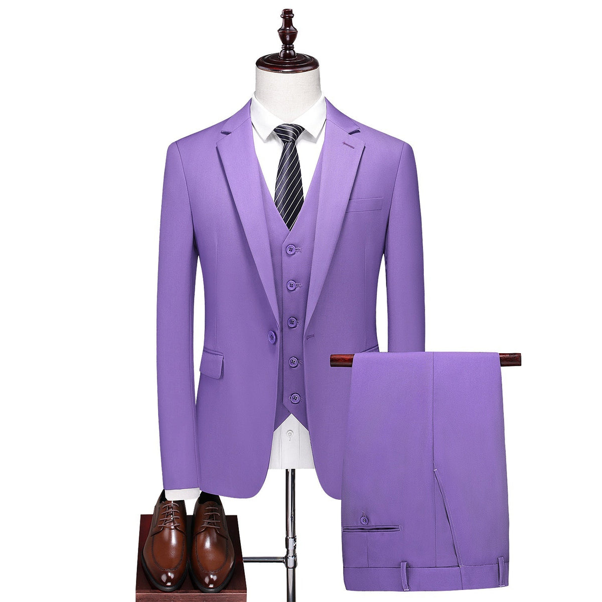 Men's purple three-piece suit, including a blazer, vest, and trousers, displayed on a mannequin with a white shirt and