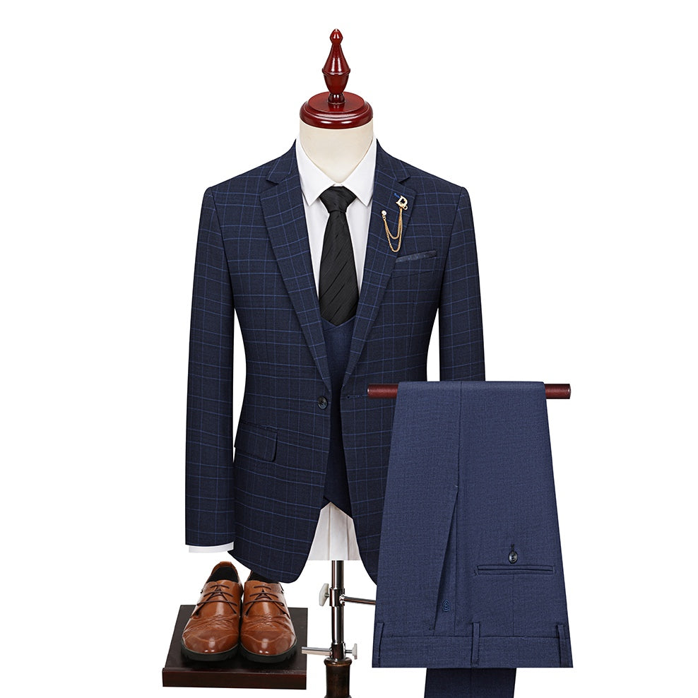 Close-up of a men's navy blue plaid 3-piece suit jacket with a gold chain lapel pin, vest, and trousers.