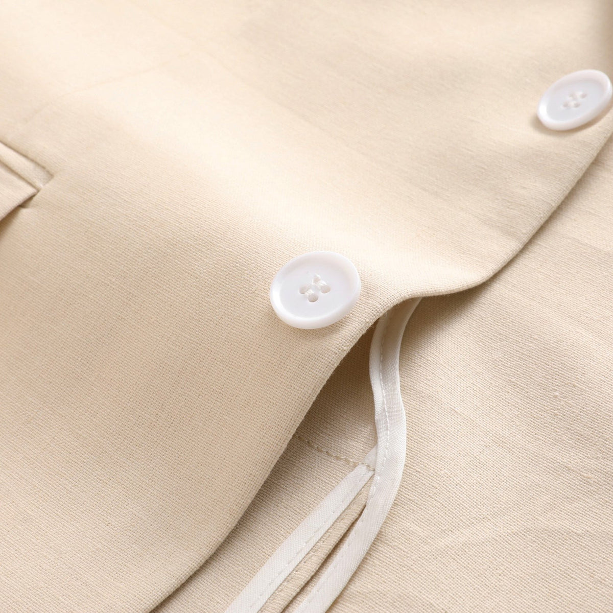 Front view of a men's beige two-piece suit, featuring a single-breasted jacket with two white buttons and matching flat-front