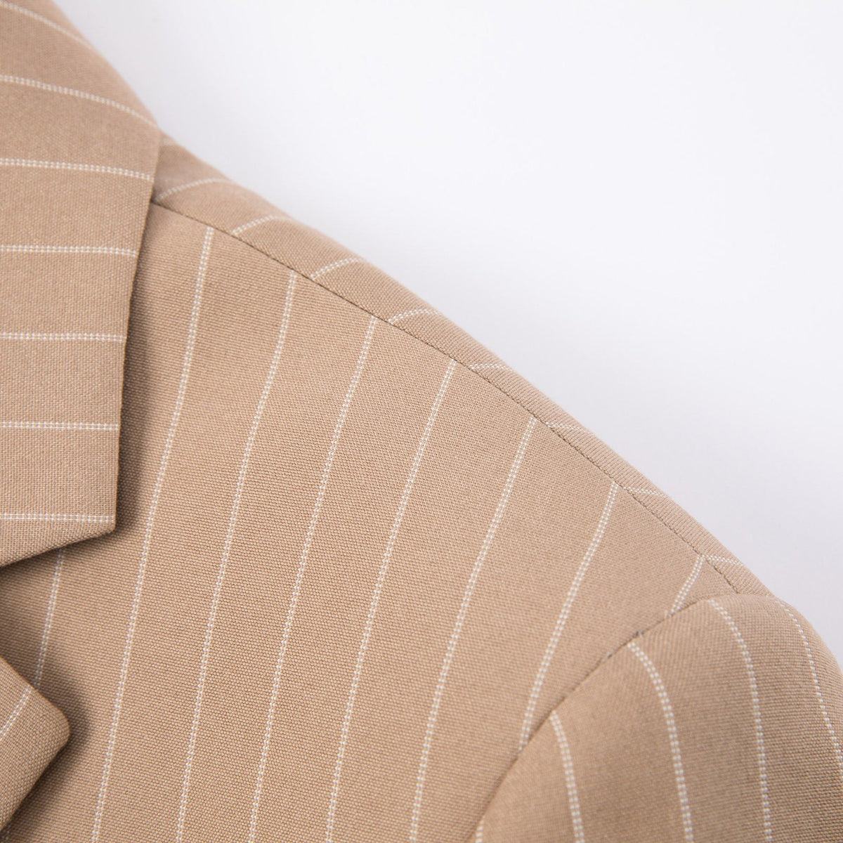 Men's beige pinstripe three-piece suit with a single-breasted jacket, double-breasted vest, and matching trousers, styled