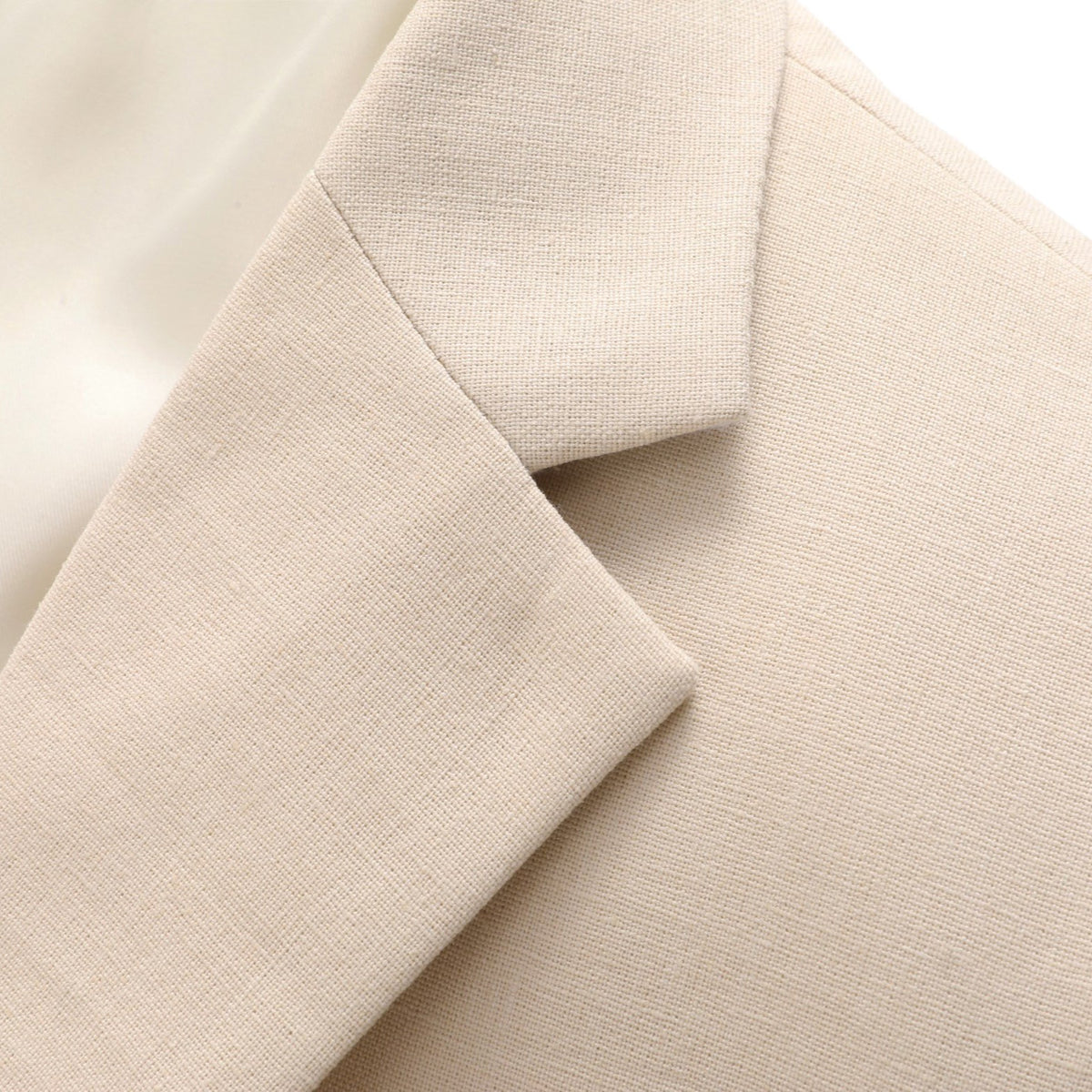Front view of a men's beige two-piece suit, featuring a single-breasted jacket with two white buttons and matching flat-front