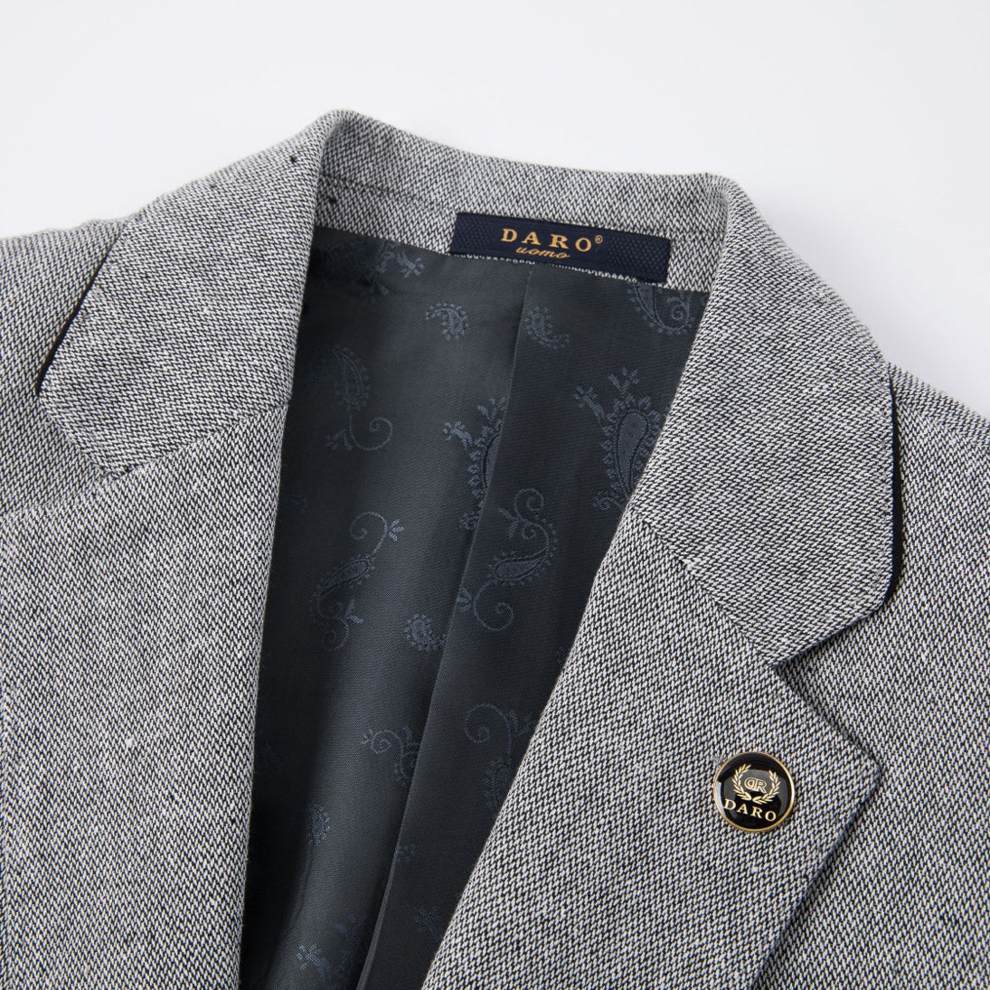 A men's grey textured three-piece suit with a single-breasted jacket, vest, and trousers, featuring black elbow patches on