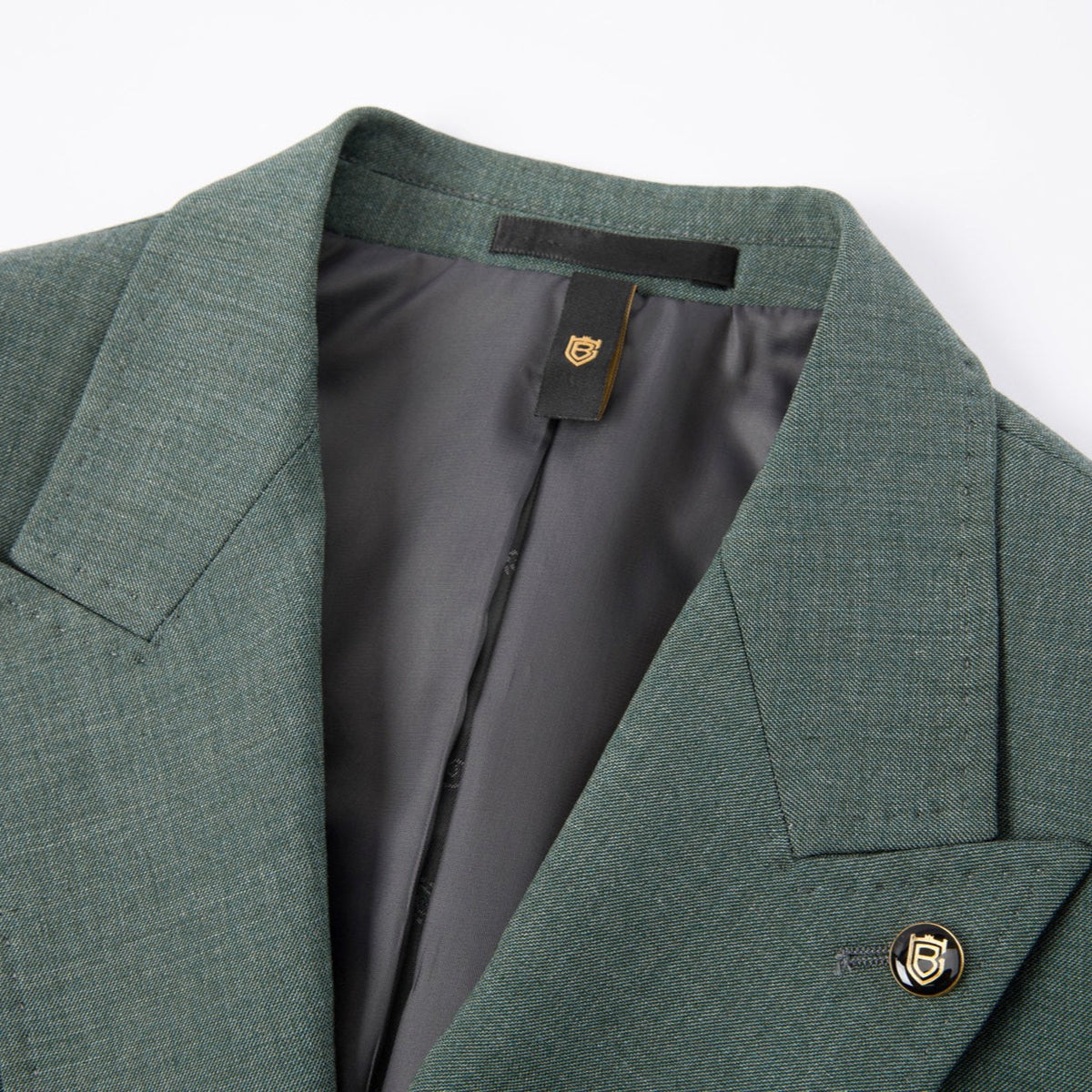 Full view of a men's green textured double-breasted suit with a yellow patterned tie, displayed on a mannequin, with matching