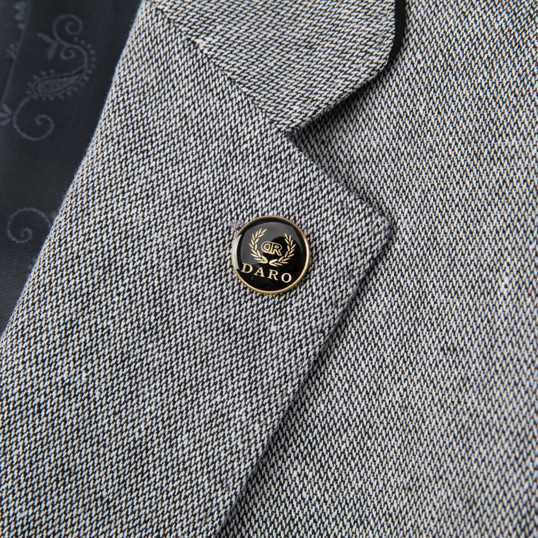A men's grey textured three-piece suit with a single-breasted jacket, vest, and trousers, featuring black elbow patches on