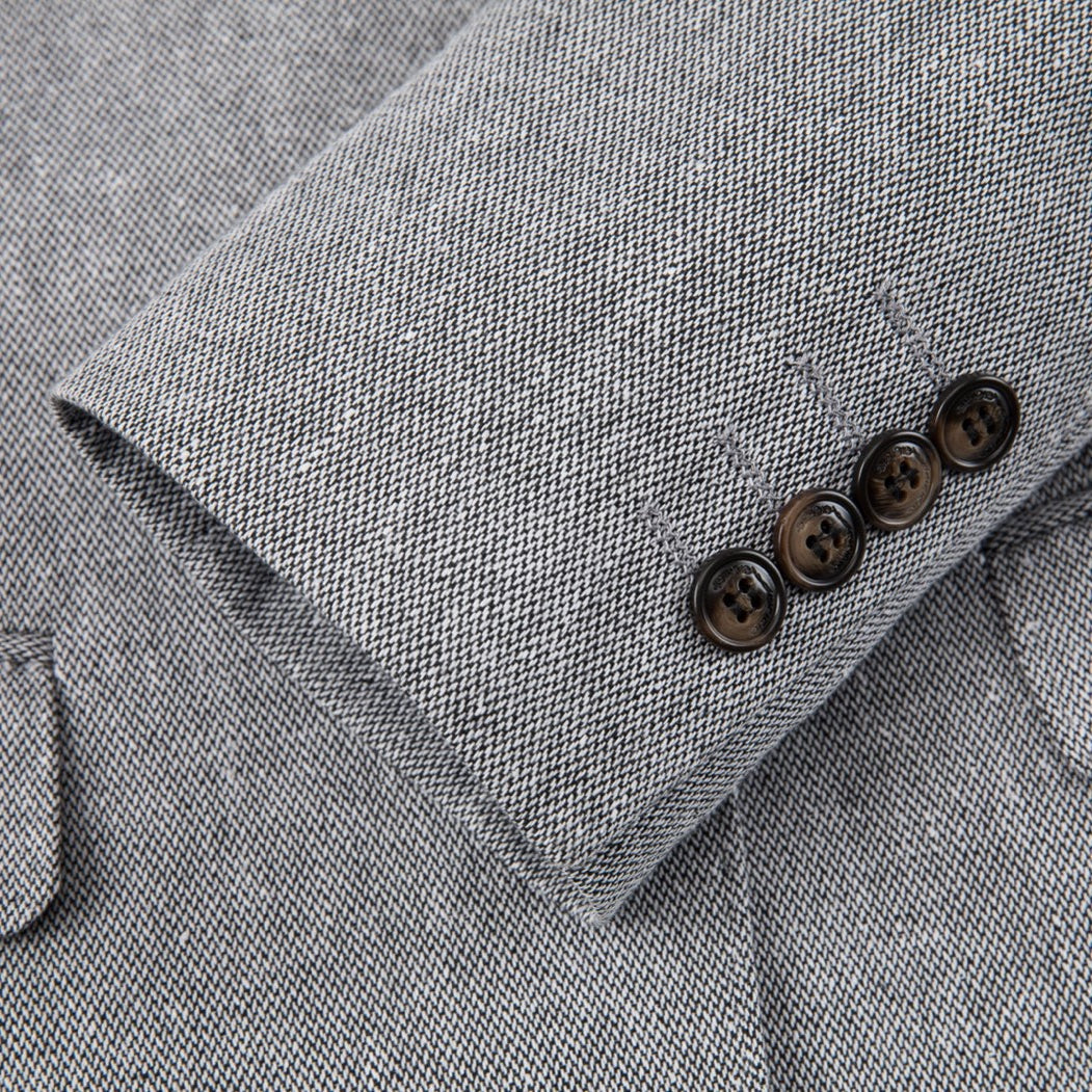 A men's grey textured three-piece suit with a single-breasted jacket, vest, and trousers, featuring black elbow patches on