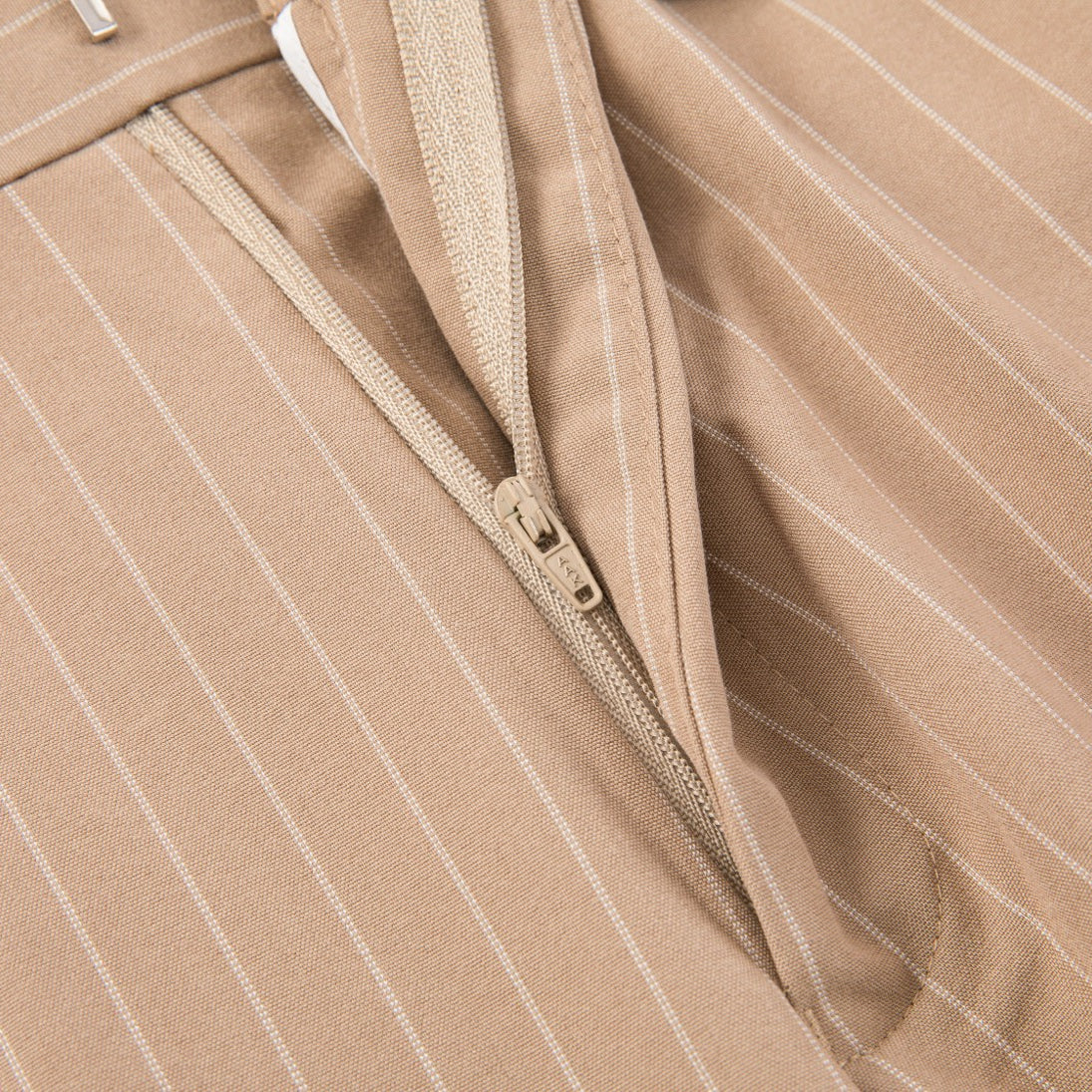 Men's beige pinstripe three-piece suit with a single-breasted jacket, double-breasted vest, and matching trousers, styled