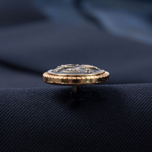 Full view of a men's navy double-breasted suit with gold buttons, a peak lapel, and a decorative brooch, paired with matching